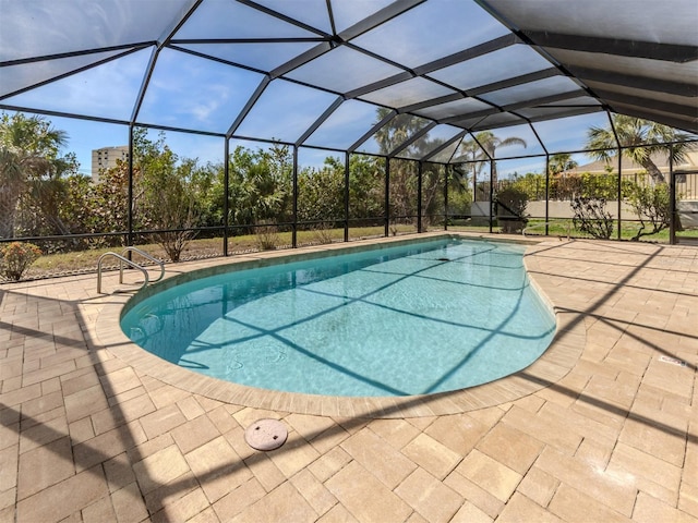 outdoor pool with a patio area and glass enclosure