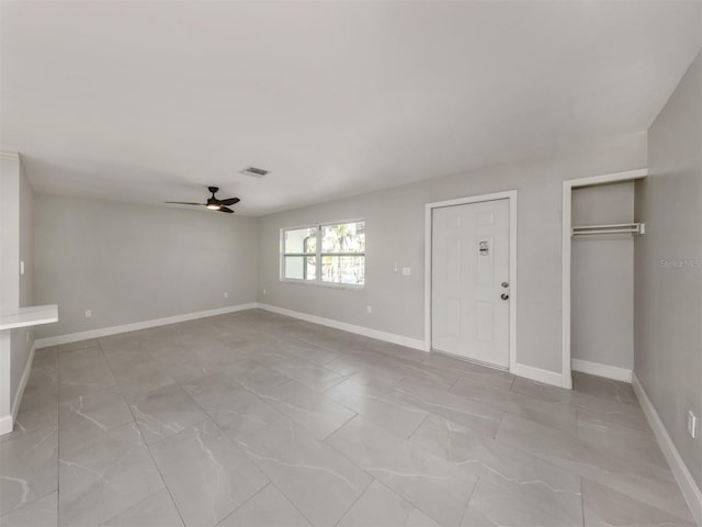 interior space with baseboards, visible vents, and a ceiling fan