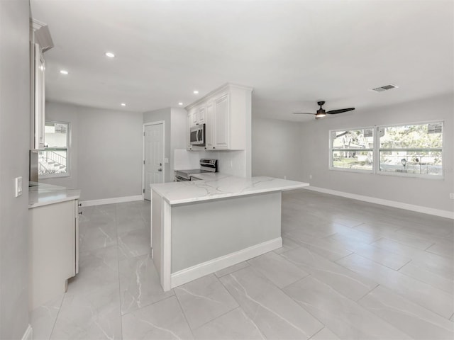 kitchen with light stone counters, visible vents, baseboards, white cabinets, and appliances with stainless steel finishes