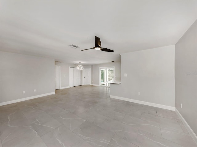 spare room with ceiling fan, visible vents, and baseboards