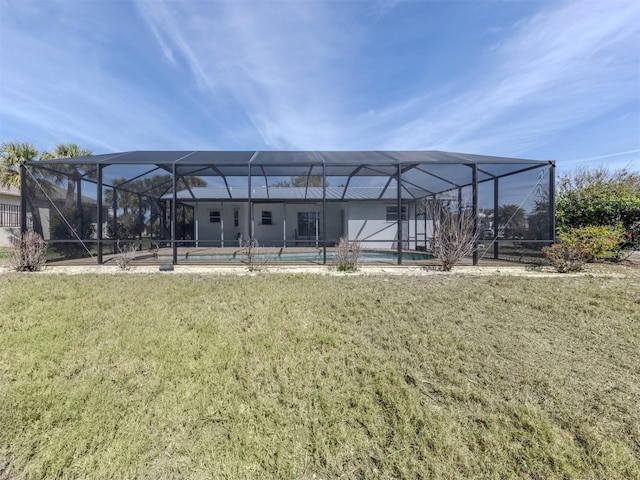 back of property with a yard, a lanai, and an outdoor pool