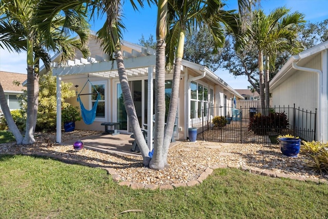 rear view of house featuring a patio, a yard, and fence