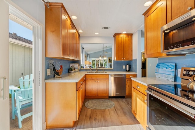 kitchen featuring light wood-type flooring, visible vents, appliances with stainless steel finishes, and light countertops