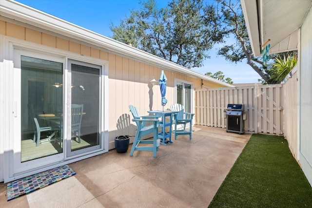 view of patio featuring a grill and fence