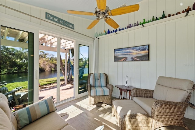 sunroom / solarium featuring a water view and ceiling fan