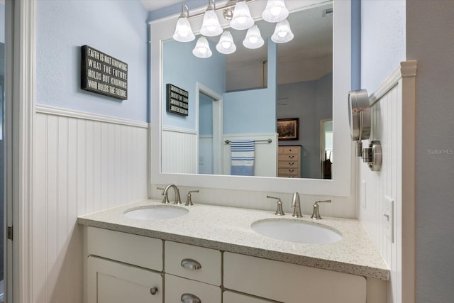 bathroom with double vanity, wainscoting, a sink, and visible vents