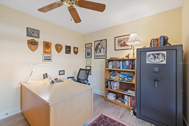 office area featuring light wood-type flooring, ceiling fan, and baseboards