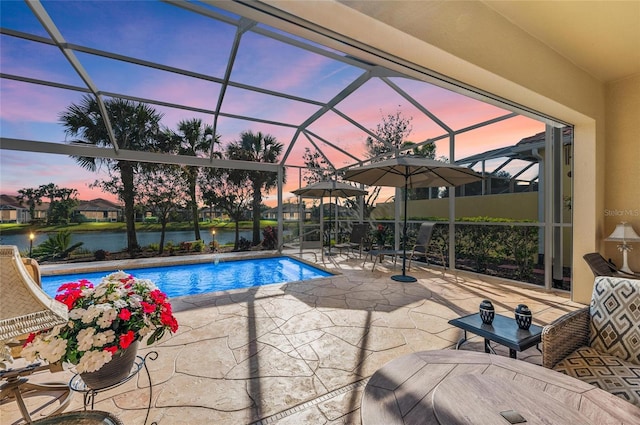 outdoor pool featuring a water view, glass enclosure, and a patio