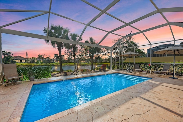 pool at dusk featuring a patio area, glass enclosure, and an outdoor pool