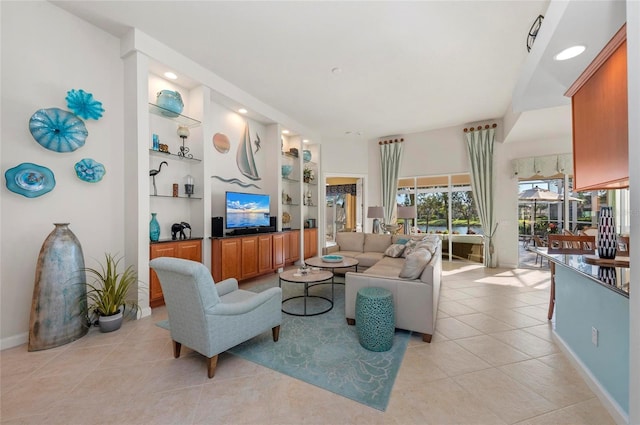 living room featuring light tile patterned floors, built in shelves, baseboards, and recessed lighting