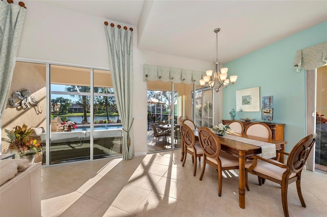 dining area with lofted ceiling, an inviting chandelier, and light tile patterned floors