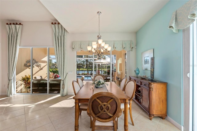 dining area with a chandelier, baseboards, and light tile patterned floors