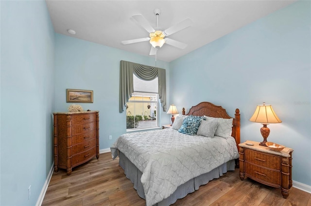 bedroom featuring ceiling fan, baseboards, and wood finished floors