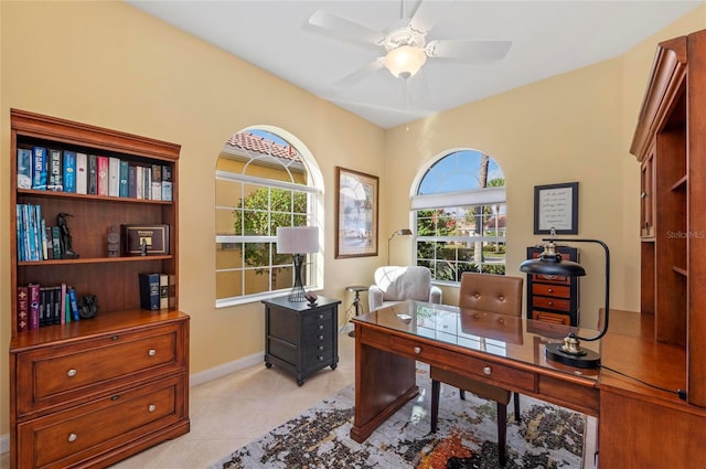 home office with ceiling fan, light tile patterned floors, baseboards, and a healthy amount of sunlight