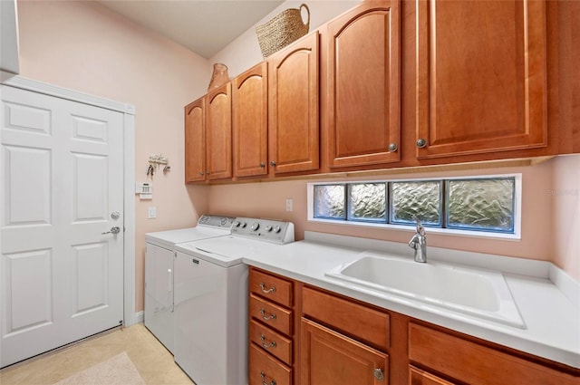 clothes washing area featuring separate washer and dryer, a sink, and cabinet space