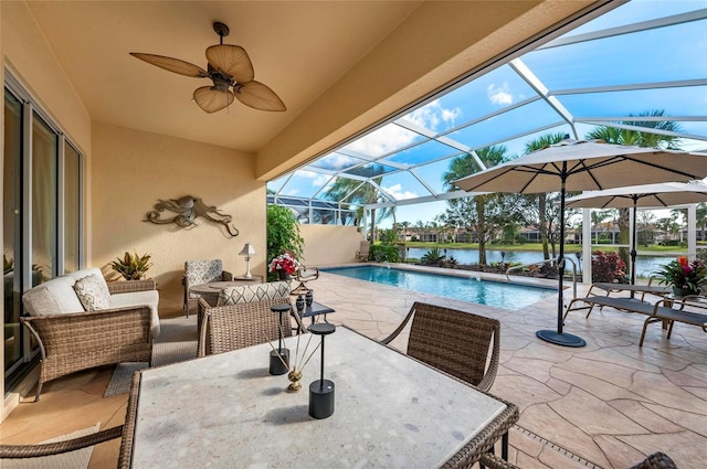 view of patio with a ceiling fan, outdoor dining area, glass enclosure, and an outdoor pool