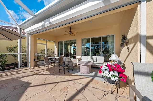 view of patio / terrace with glass enclosure, outdoor lounge area, and a ceiling fan