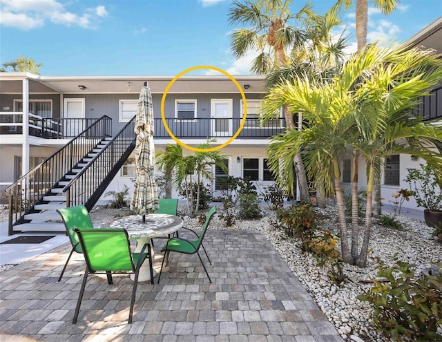 view of patio / terrace featuring outdoor dining space and stairway