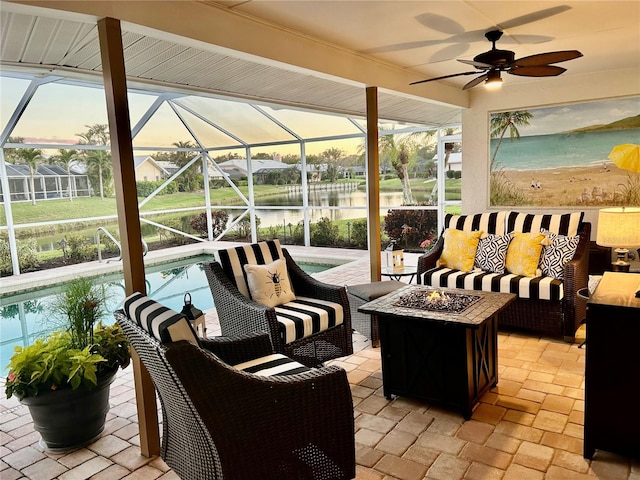 view of patio / terrace featuring a water view, glass enclosure, an outdoor pool, and an outdoor living space with a fire pit