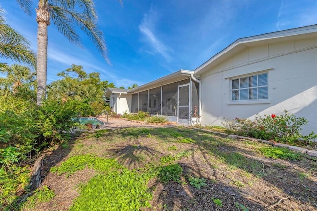 view of yard featuring an outdoor pool and a sunroom
