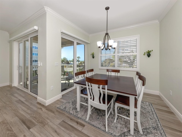 dining space featuring an inviting chandelier, baseboards, crown molding, and wood finished floors