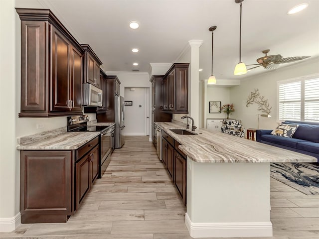 kitchen with crown molding, appliances with stainless steel finishes, a sink, dark brown cabinetry, and a peninsula