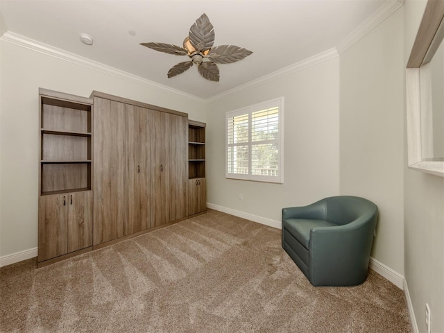 sitting room with carpet floors, a ceiling fan, baseboards, and crown molding