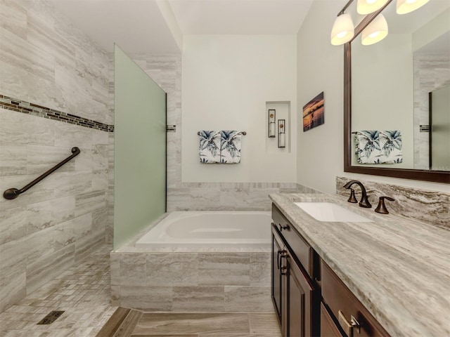 bathroom with tiled shower, vanity, and a bath