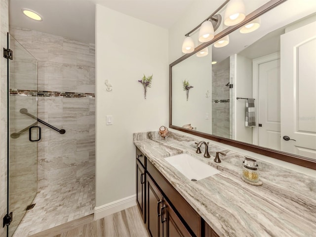 bathroom featuring a shower stall, vanity, and baseboards