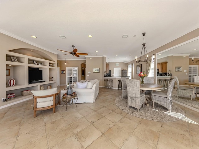 living room with recessed lighting, built in shelves, crown molding, and ceiling fan with notable chandelier