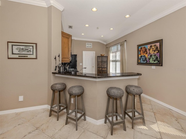 kitchen featuring visible vents, baseboards, and a breakfast bar