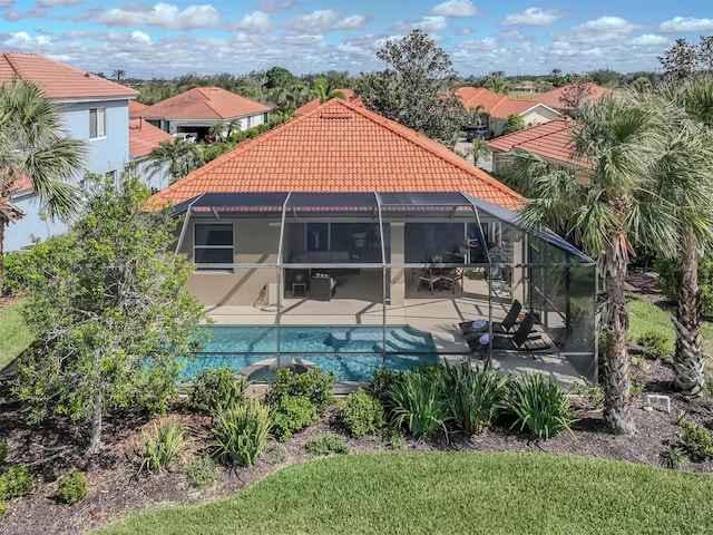 rear view of house with an outdoor pool, a patio, a tiled roof, a lanai, and stucco siding