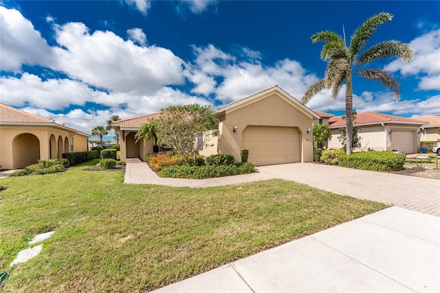 view of front facade featuring decorative driveway, stucco siding, an attached garage, a tiled roof, and a front lawn