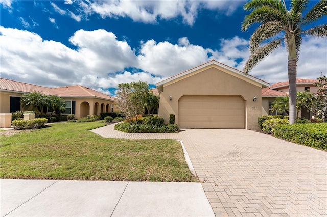 view of front of home with a garage, stucco siding, a tiled roof, decorative driveway, and a front yard