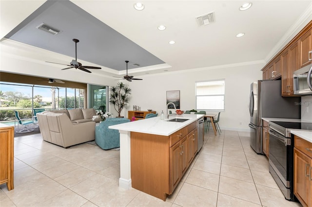 kitchen featuring a tray ceiling, stainless steel appliances, visible vents, ornamental molding, and a sink