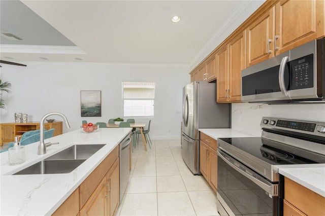 kitchen with light stone counters, stainless steel appliances, a sink, visible vents, and brown cabinetry