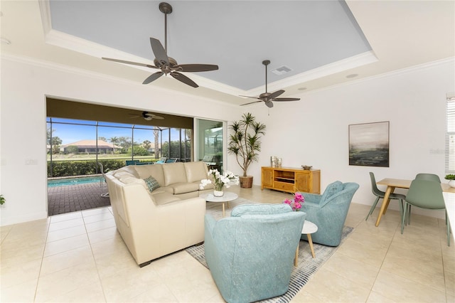 living area featuring ornamental molding, a tray ceiling, and visible vents