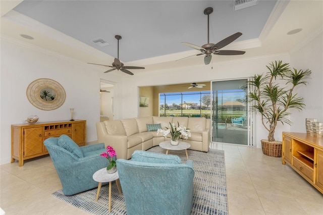 living room featuring ornamental molding, a tray ceiling, light tile patterned floors, and visible vents