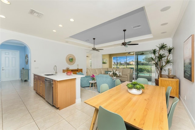 dining room featuring a tray ceiling, arched walkways, crown molding, light tile patterned floors, and visible vents