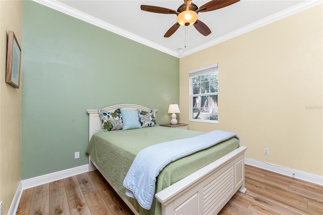 bedroom with light wood-type flooring, baseboards, ornamental molding, and a ceiling fan