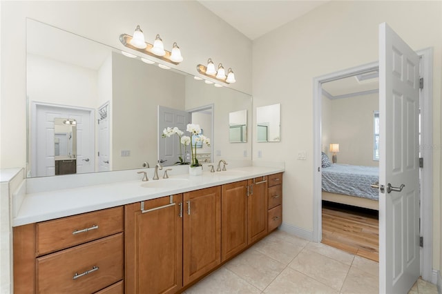 bathroom with tile patterned flooring, a sink, ensuite bath, and double vanity