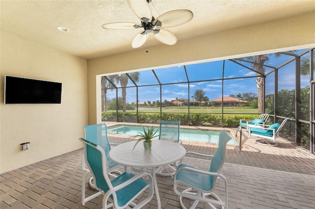 exterior space featuring a lanai, ceiling fan, and an outdoor pool