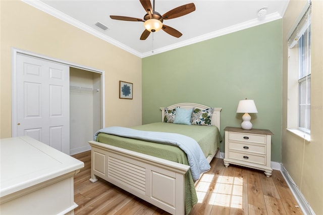 bedroom featuring light wood finished floors, visible vents, ornamental molding, and a closet