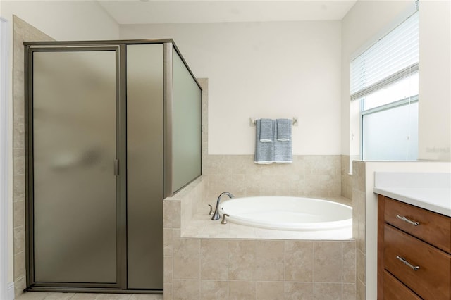 bathroom featuring a garden tub, a shower stall, and vanity