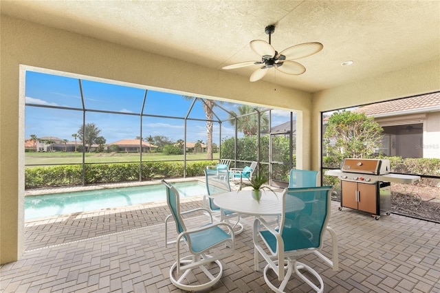 sunroom with a pool and a ceiling fan