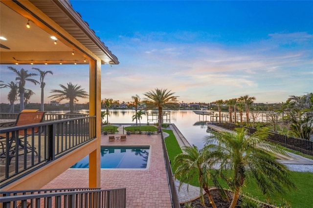 pool featuring a water view and a patio