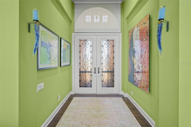 entryway with dark wood-style floors, french doors, and baseboards