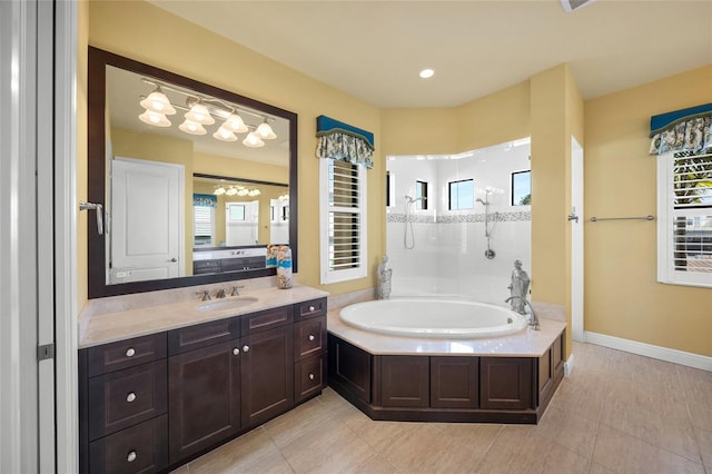 full bath featuring baseboards, vanity, a bath, and a healthy amount of sunlight