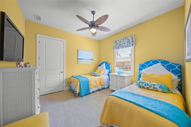 bedroom with ceiling fan, visible vents, and baseboards