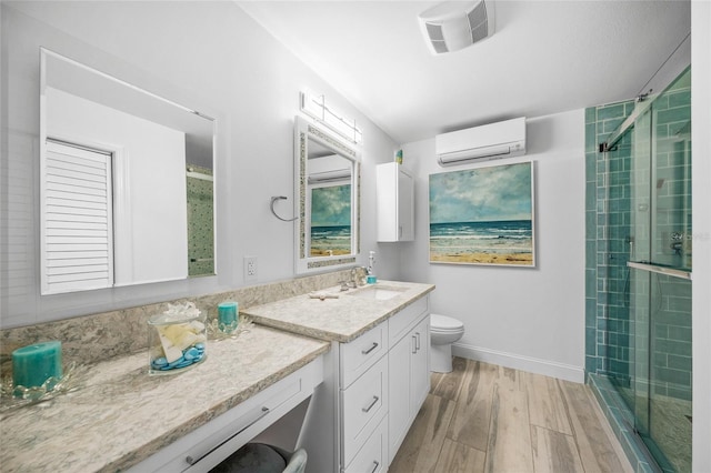 full bathroom with visible vents, a wall unit AC, toilet, wood finished floors, and vanity